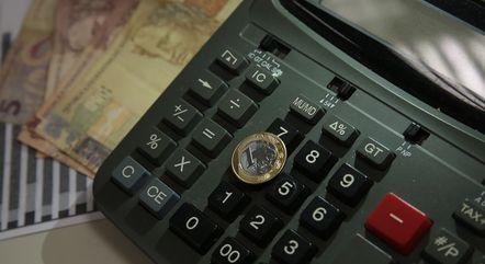 dinheiro-cedulas-e-moedas-de-reais-e-uma-calculadora-19092022172407722-1